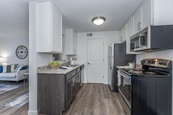 A kitchen with a black stove top oven and white cabinets.